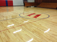 shiny basketball court floor with school logo in center
