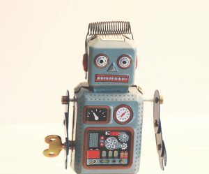 gray robot toy with wind up crank and various buttons and displays